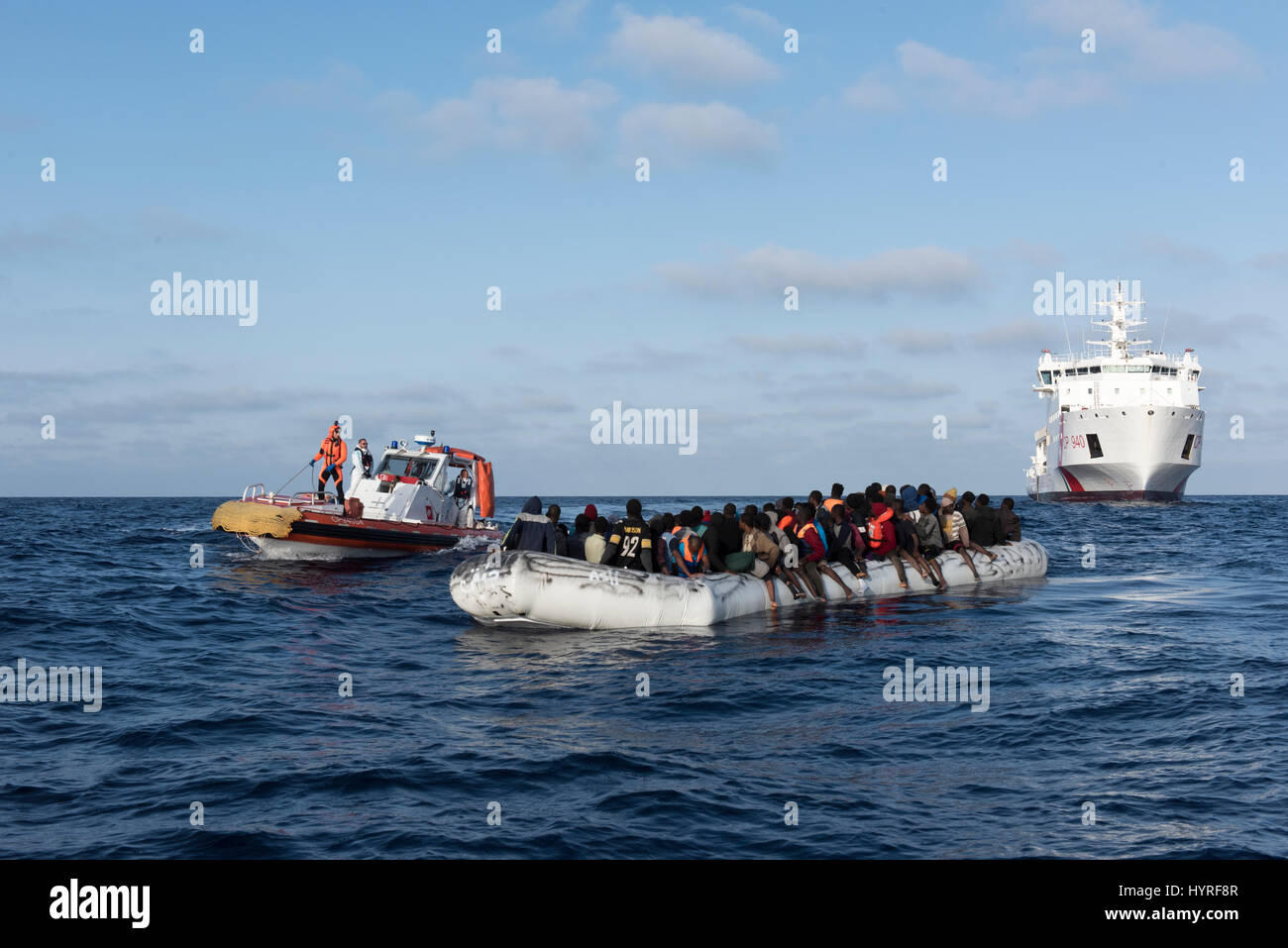 Italian Coastguard vessel Dattilo is starting a rescue operation in the mediterrean sea to safe refugees from a non seaworthy rubberboat offshore liby Stock Photo