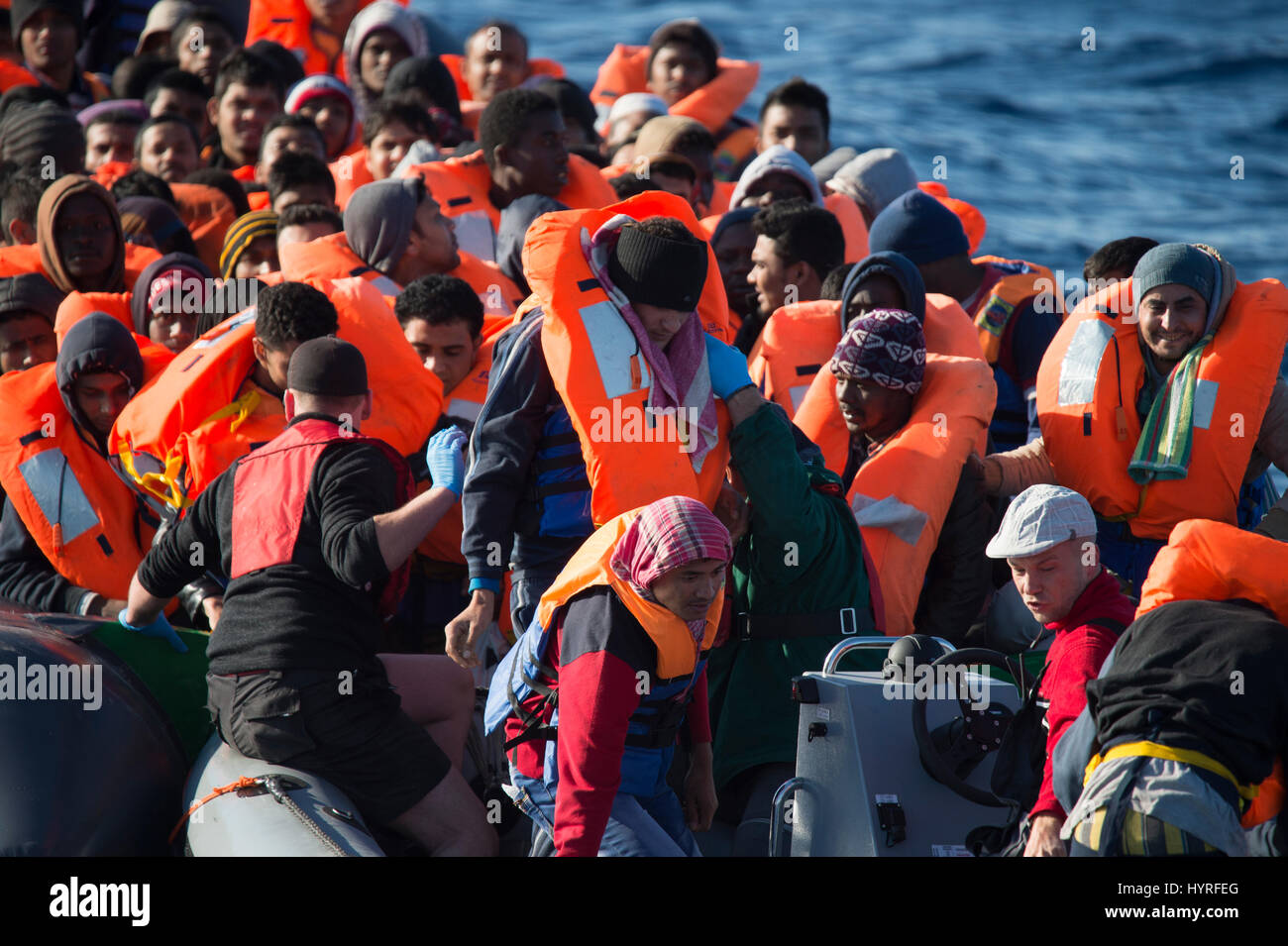 A non seaworthy rubberboat with around 150 people on board offshore Lybia trying to cross the mediterrean sea to europe. Because of the condition, whi Stock Photo