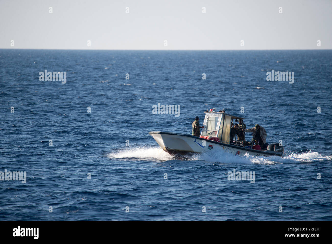 A small boat with 5 people, calling themself Libyan Coastguard was following a rubberboat with migrants and watching and documenting the SAR operation Stock Photo