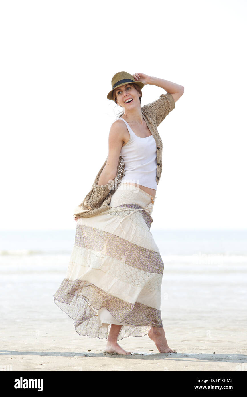 Portrait of a cheerful middle aged woman walking on the beach Stock Photo
