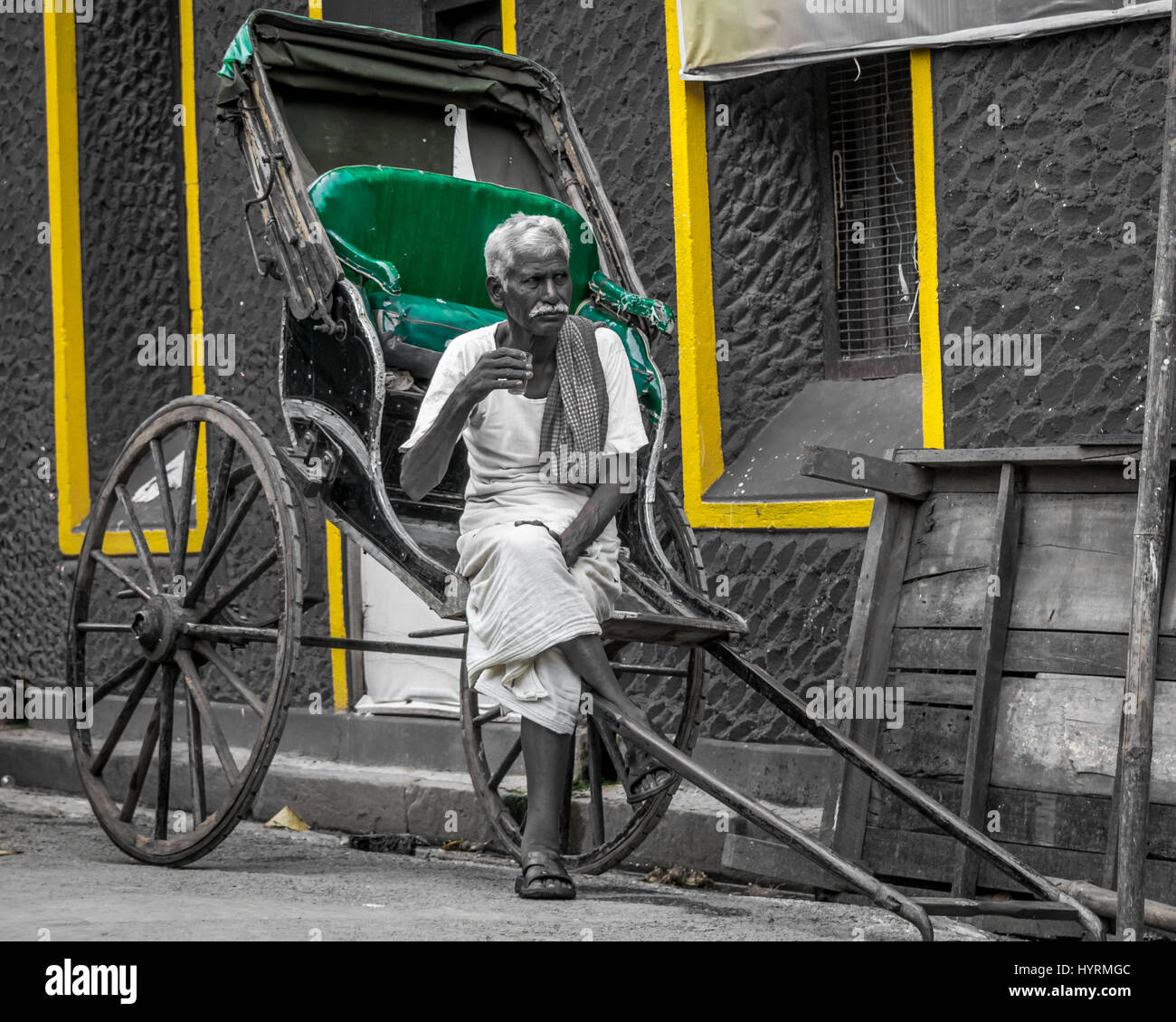 A hand rickshaw puller taking a tea beak and being thoughtful Stock Photo