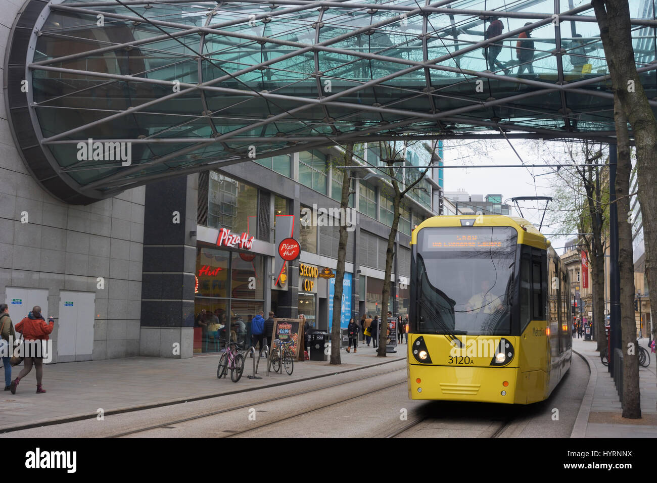 Metrolink trams in Corporation street, Manchester city centre passing the Arndale centre. Stock Photo