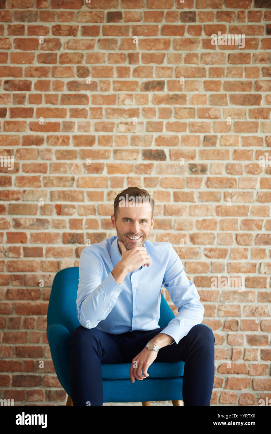 Cheerful man on the brick wall Stock Photo