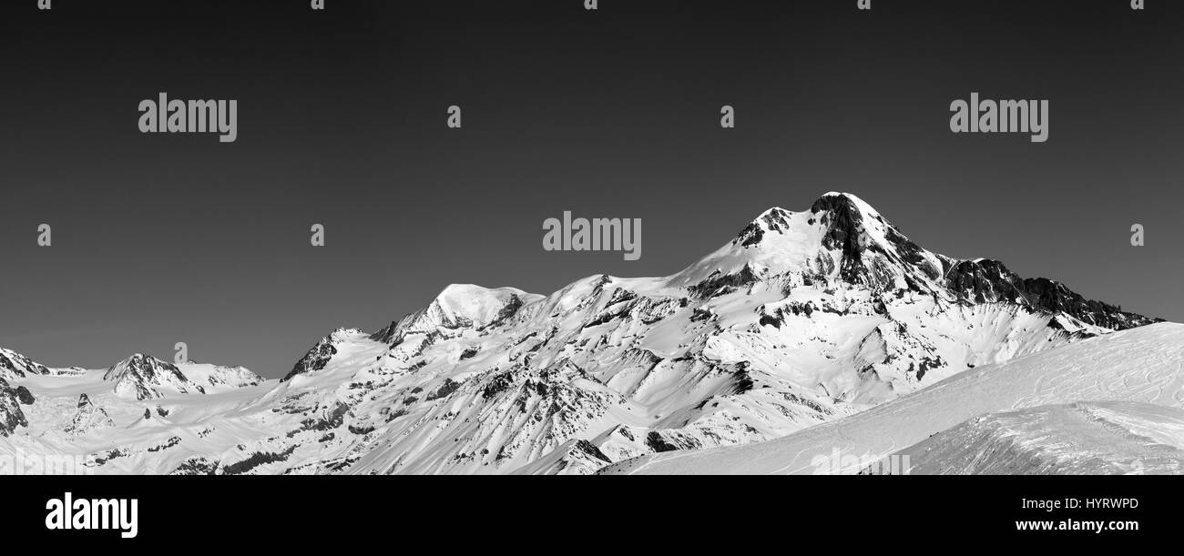 Black and white panoramic view on off-piste slope and mount Kazbek at sun winter day. Caucasus Mountains, Georgia, region Gudauri. Stock Photo