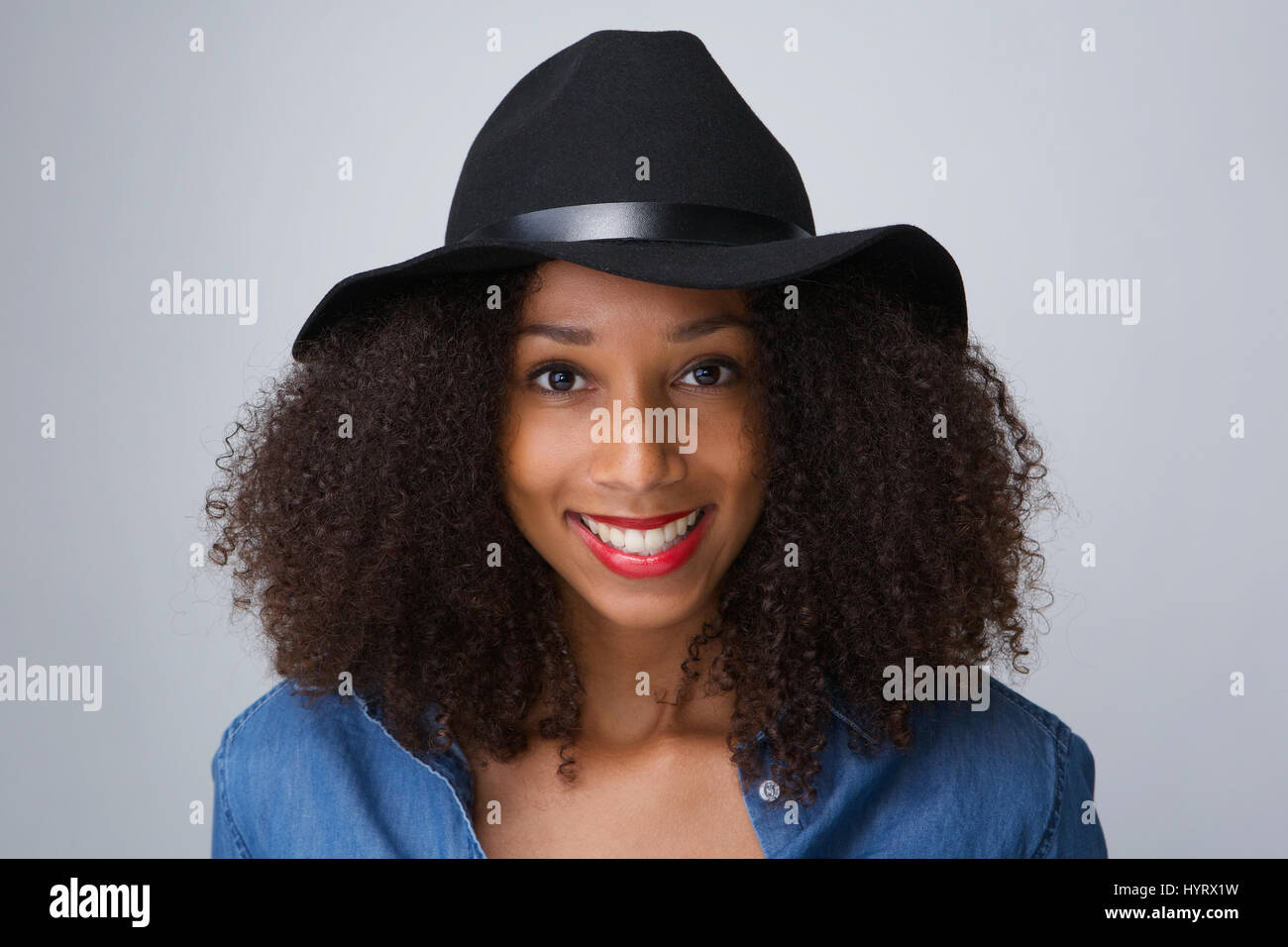 Close up portrait of a young black woman smiling with hat on isolated ...