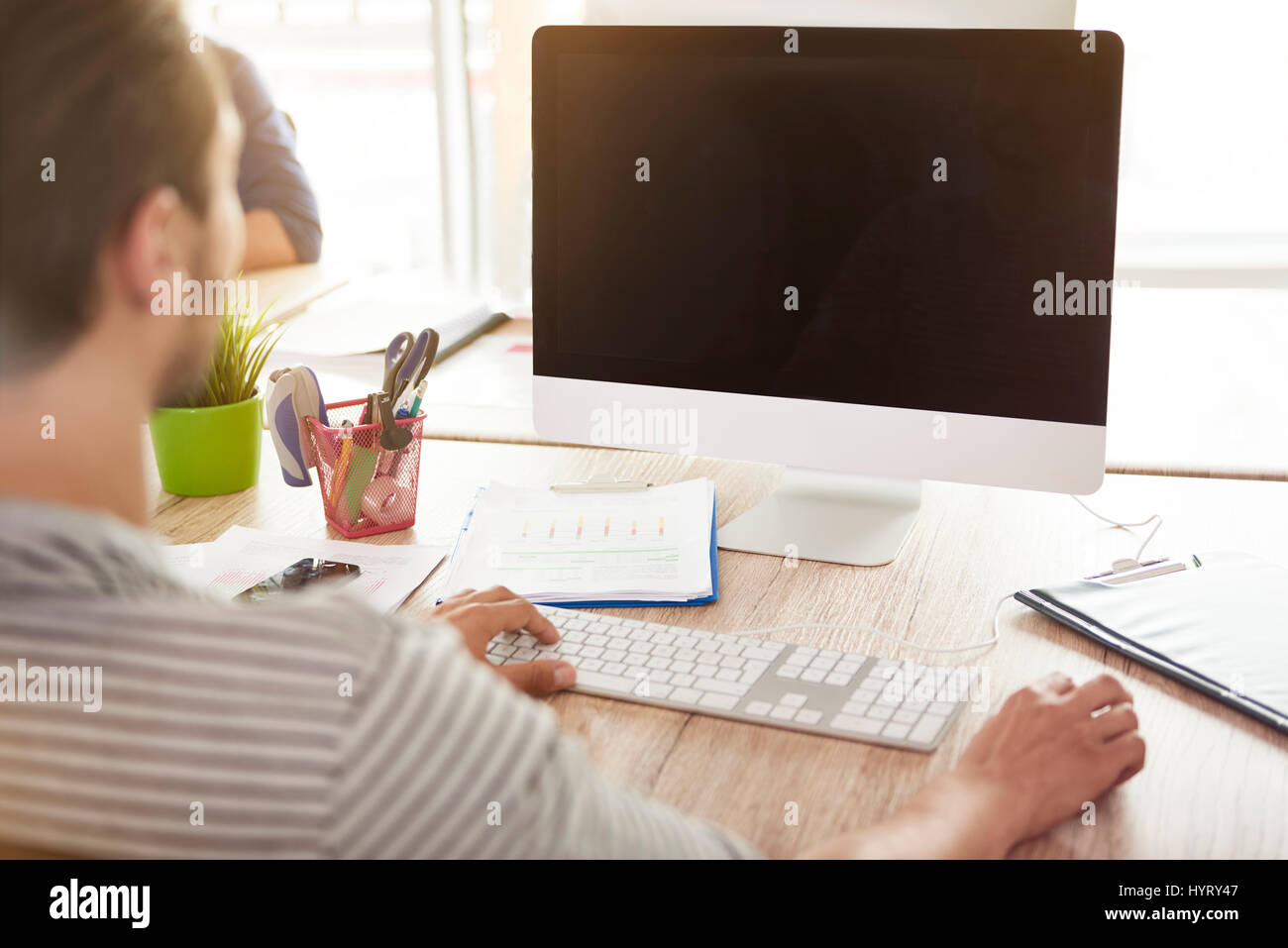 Rear view of man and his computer Stock Photo - Alamy