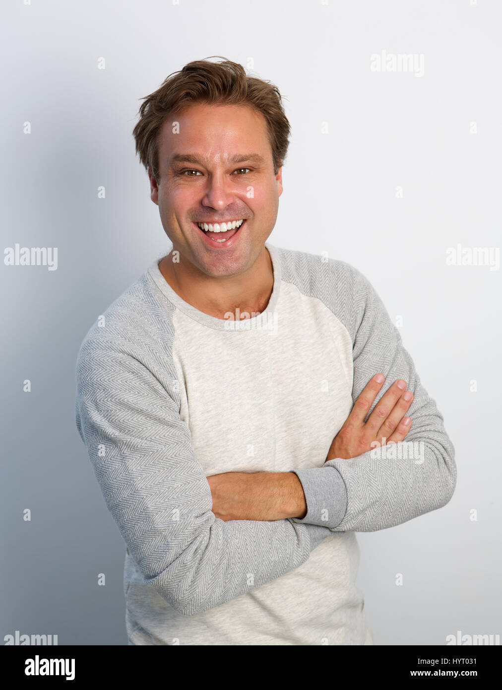 Portrait of a friendly mature man smiling with arms crossed Stock Photo ...