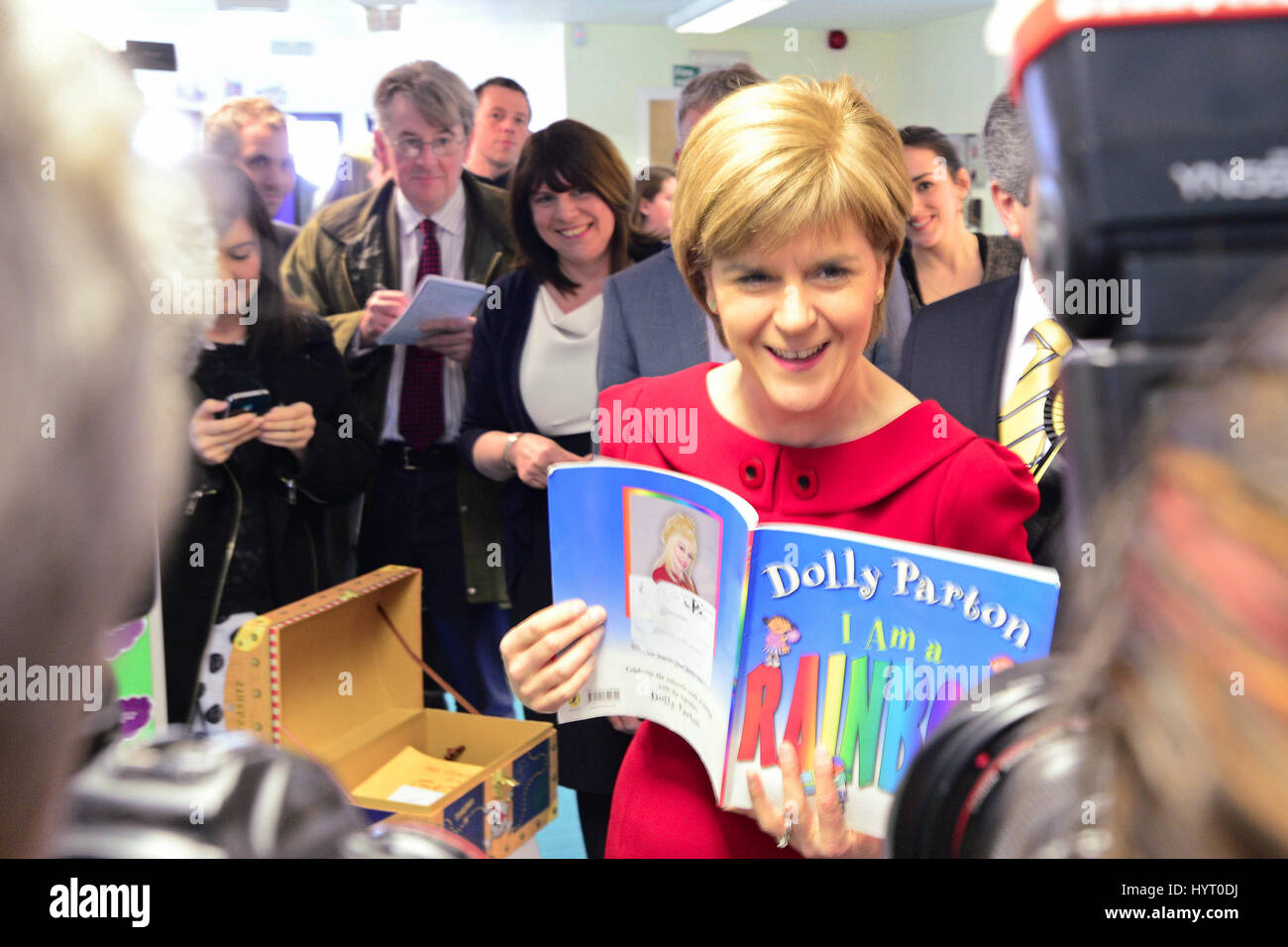 SNP leader Nicola Sturgeon jokes 'It's always Dolly Parton!' as photographers crowd round when she is handed a children's book during a tour of Barnardo's children's charity offices in Kirkcaldy Stock Photo