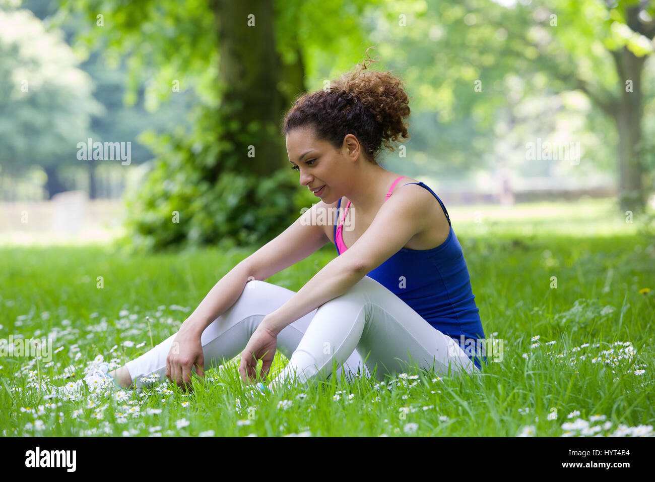 Young woman sitting outdoors in the park after workout Stock Photo Alamy