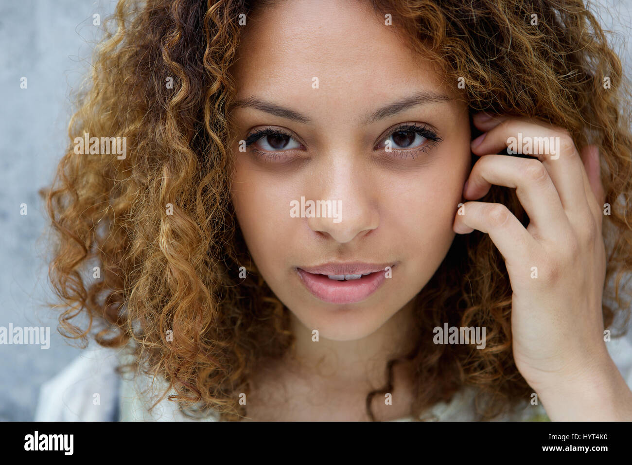 Close up portrait of a beautiful young black woman with hand in hair ...