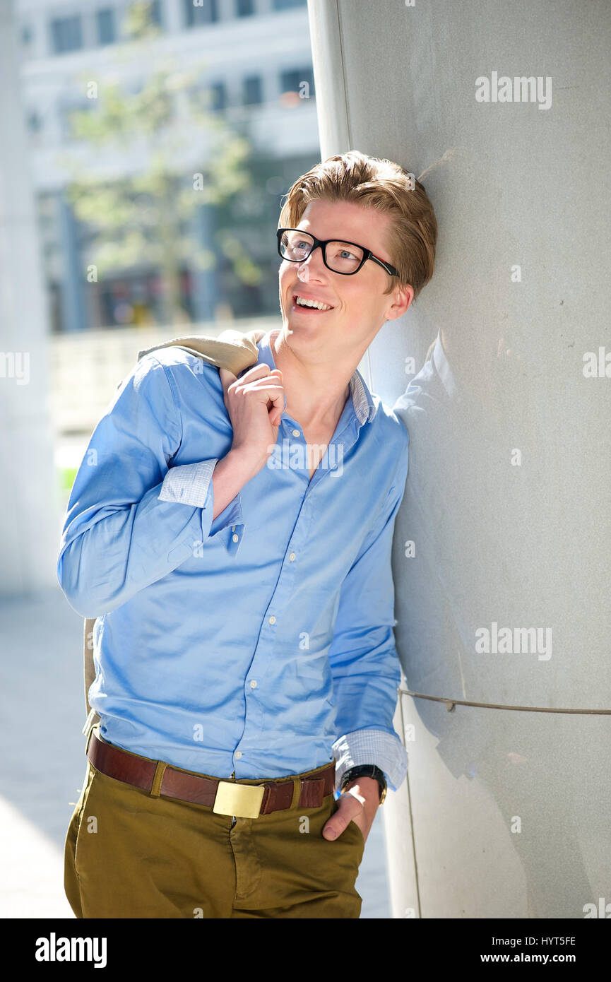 Portrait of a happy young man with glasses smiling outdoors Stock Photo ...