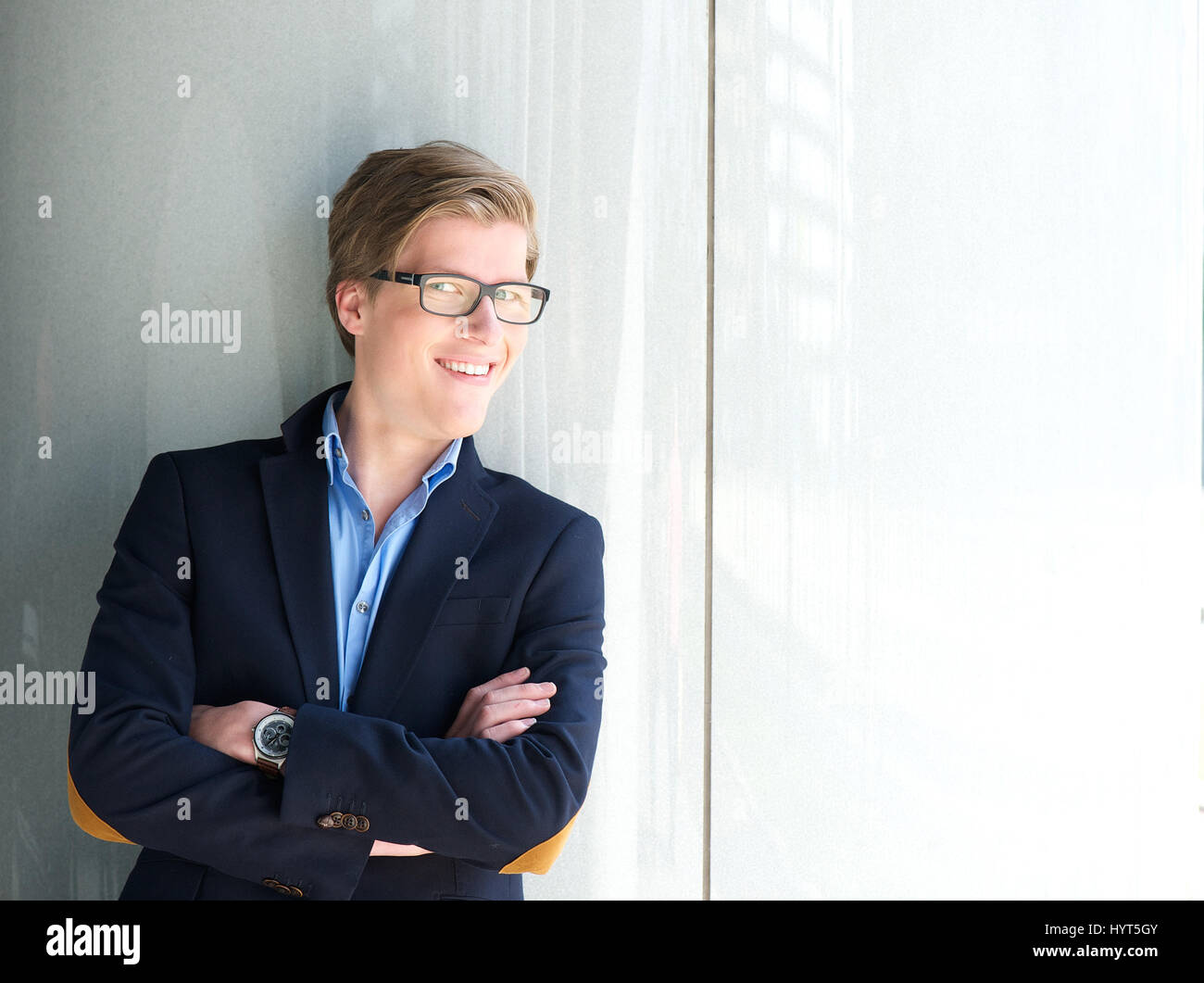 Portrait of a young businessman smiling with arms crossed Stock Photo ...