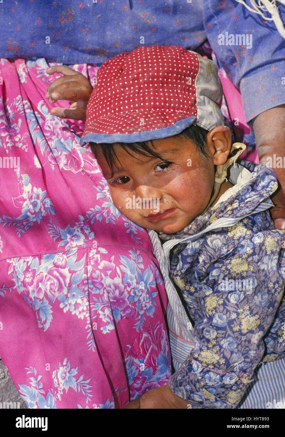 Unreleased image. for editorial usage only. A young Tarahumara  Indian boy with a runny nose holds on to his mother, in Copper Canyon, Mexico Stock Photo