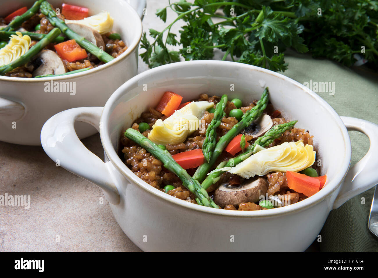 Healthy bowl of vegan paella with asparagus, mushrooms and artichoke