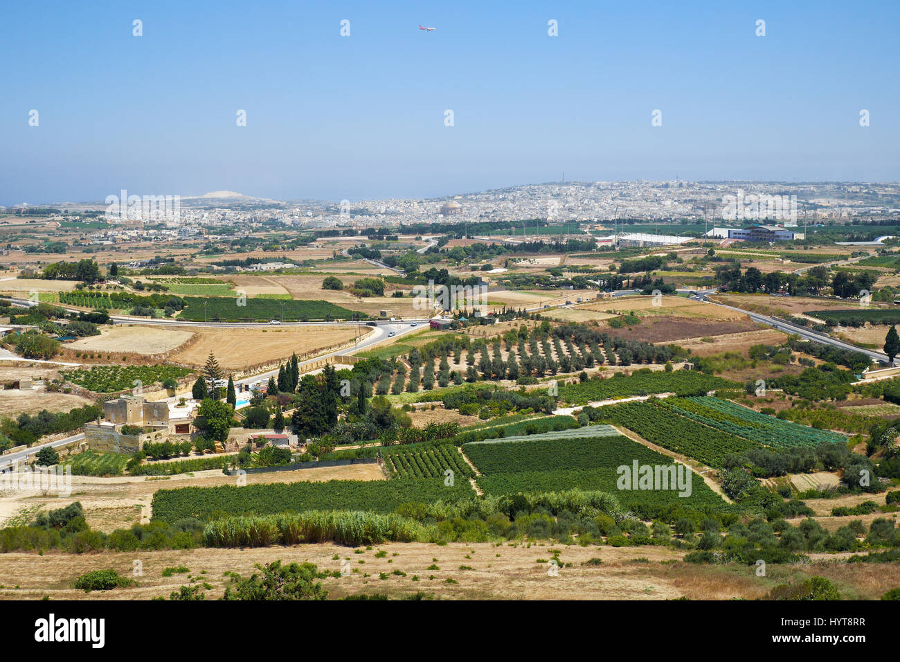 View from the Mdina defensive wall to the countryside with vineyards and gardens surrounding the old Malta capital and to the town Mosta with the huge Stock Photo