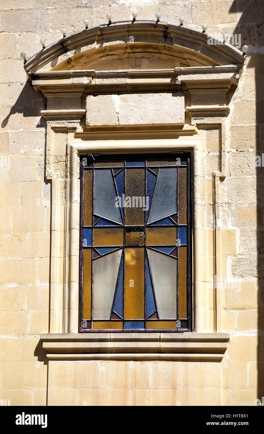 The window with a stained glass depicting a 8-pointed Maltese cross ...