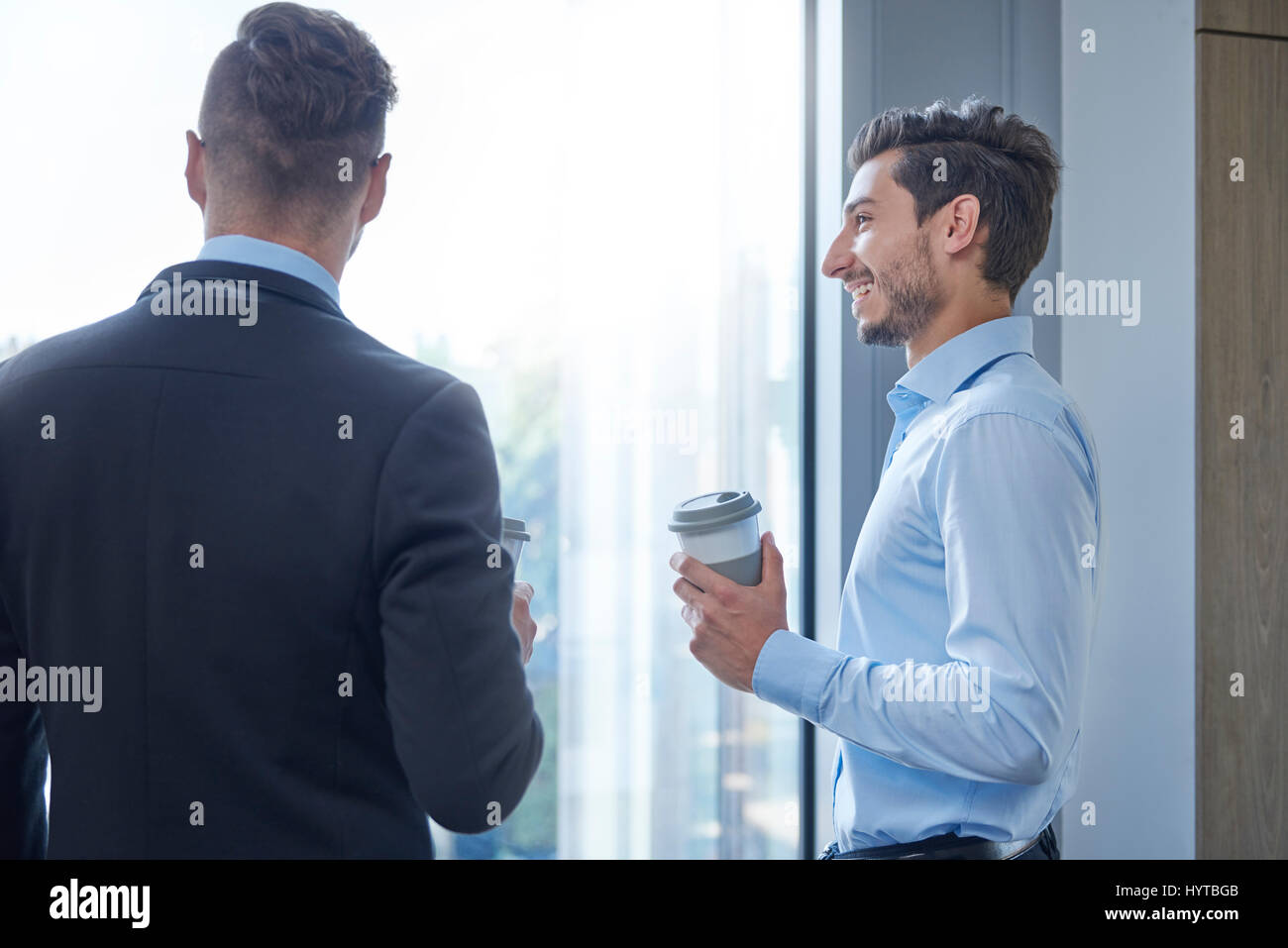 Rear view of men next to the window Stock Photo - Alamy