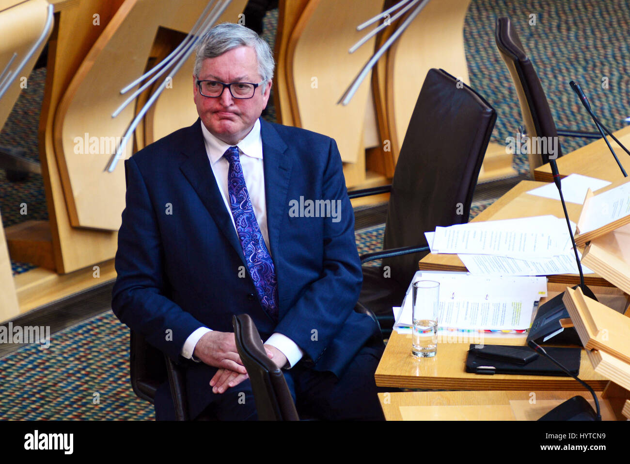 Scottish Energy Minister Fergus Ewing listens to an opposition contribution after making a statement on the Scottish Government's response to the UK Government's decision to end onshore windfarm subsidies early Stock Photo