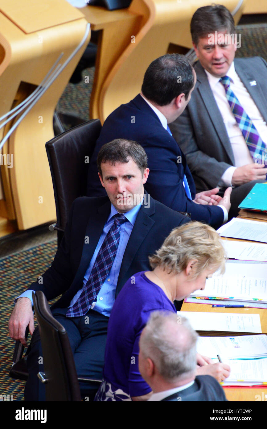 Justice Secretary Michael Matheson (C) and front bench colleagues await a vote in the Scottish Parliament during the passage of legislation ending automatic early release of prisoners in Scotland Stock Photo