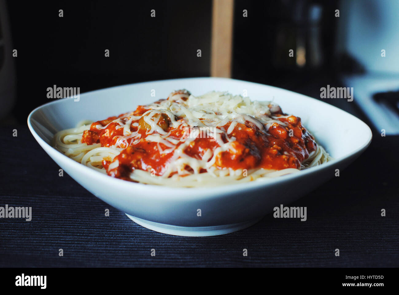 Delicious spaghetti bolognese with olives and mozzarella cheese on dark