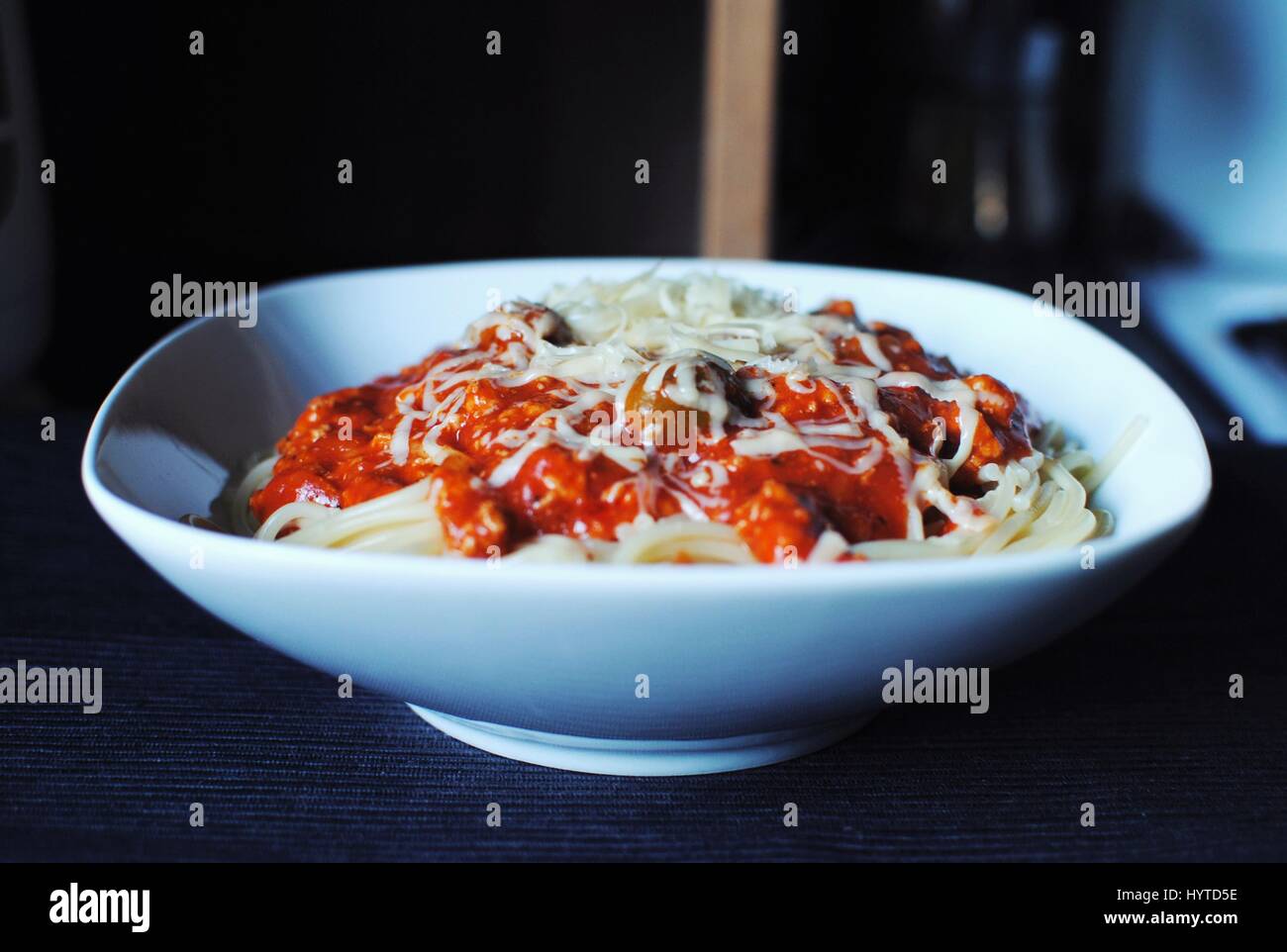 Delicious spaghetti bolognese with olives and mozzarella cheese on dark