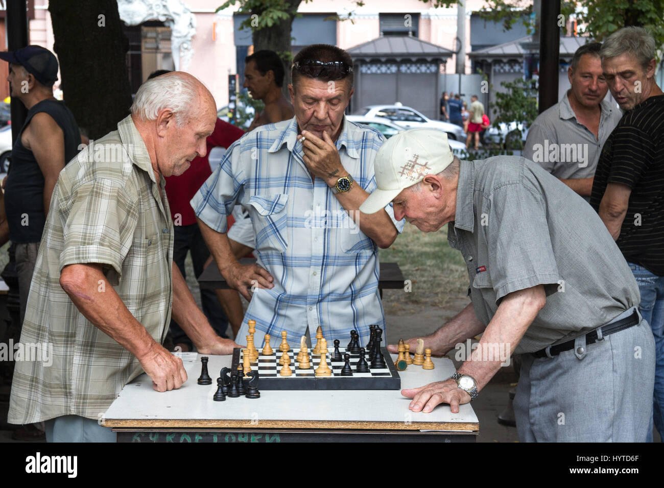 ODESSA, UKRAINE - AUGUST 14, 2015: Old men playing chess in a park of Odessa, Ukraine  Picture of aged men playing chess in one of Odessa's main parks Stock Photo