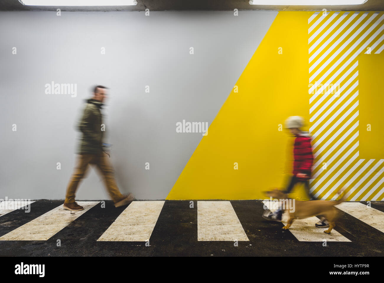 People passing in Underground passage mark with white stripes Stock Photo