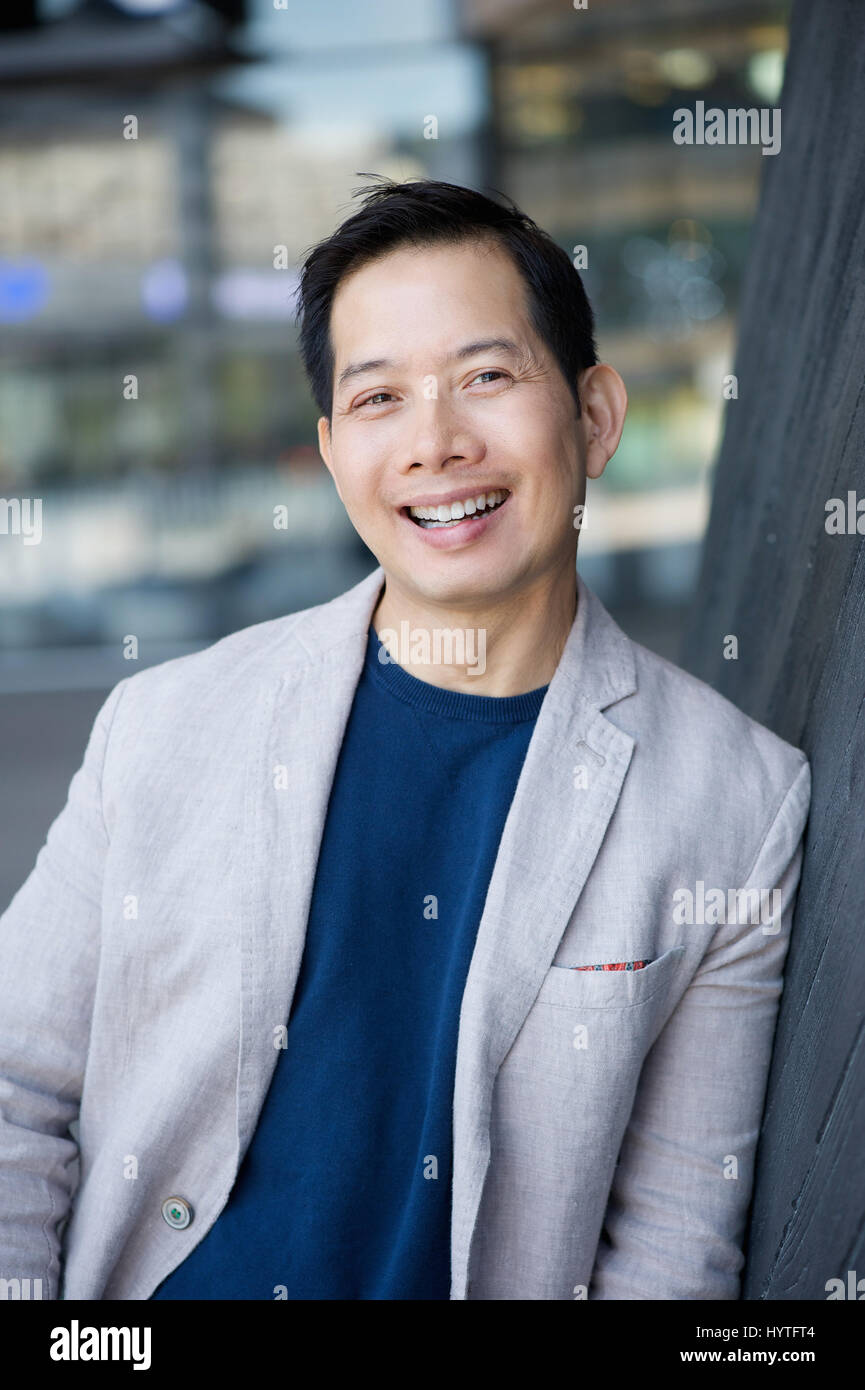 Portrait of a cool middle aged asian man smiling outdoors Stock Photo