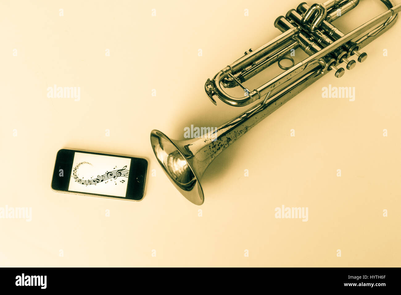 Old Trumpet with tinted screen playing music on cell phone Stock Photo