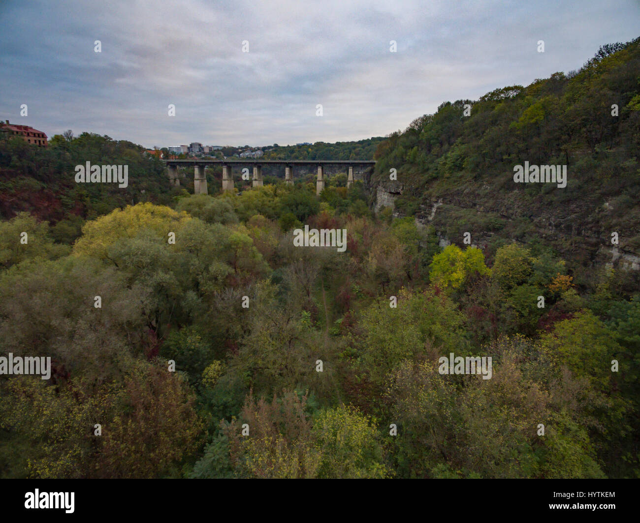 Aerial shot of the canyon of the Smotrych River towards the Novoplanivskyi Bridge in Kamianets-Podilski Ukraine. The shot is taken in autumn with the  Stock Photo
