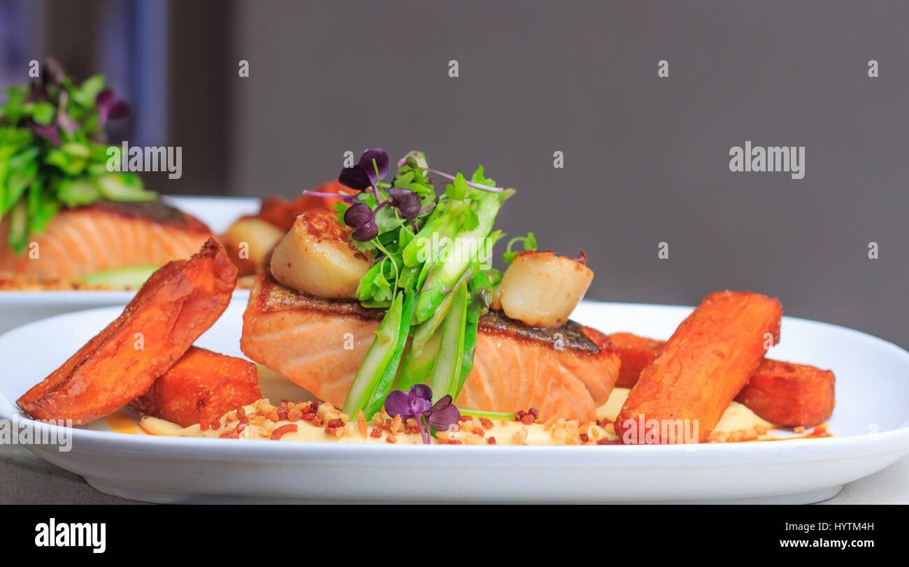 Grilled Crispy skin salmon fillet with scallops ready to serve in a restaurant , gasto pub, australia Stock Photo