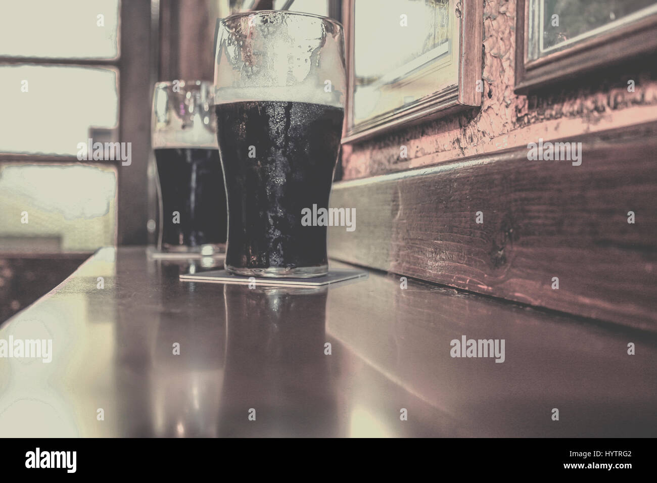 Two glasses of famous black Irish stout in Irish pub on wooden bar