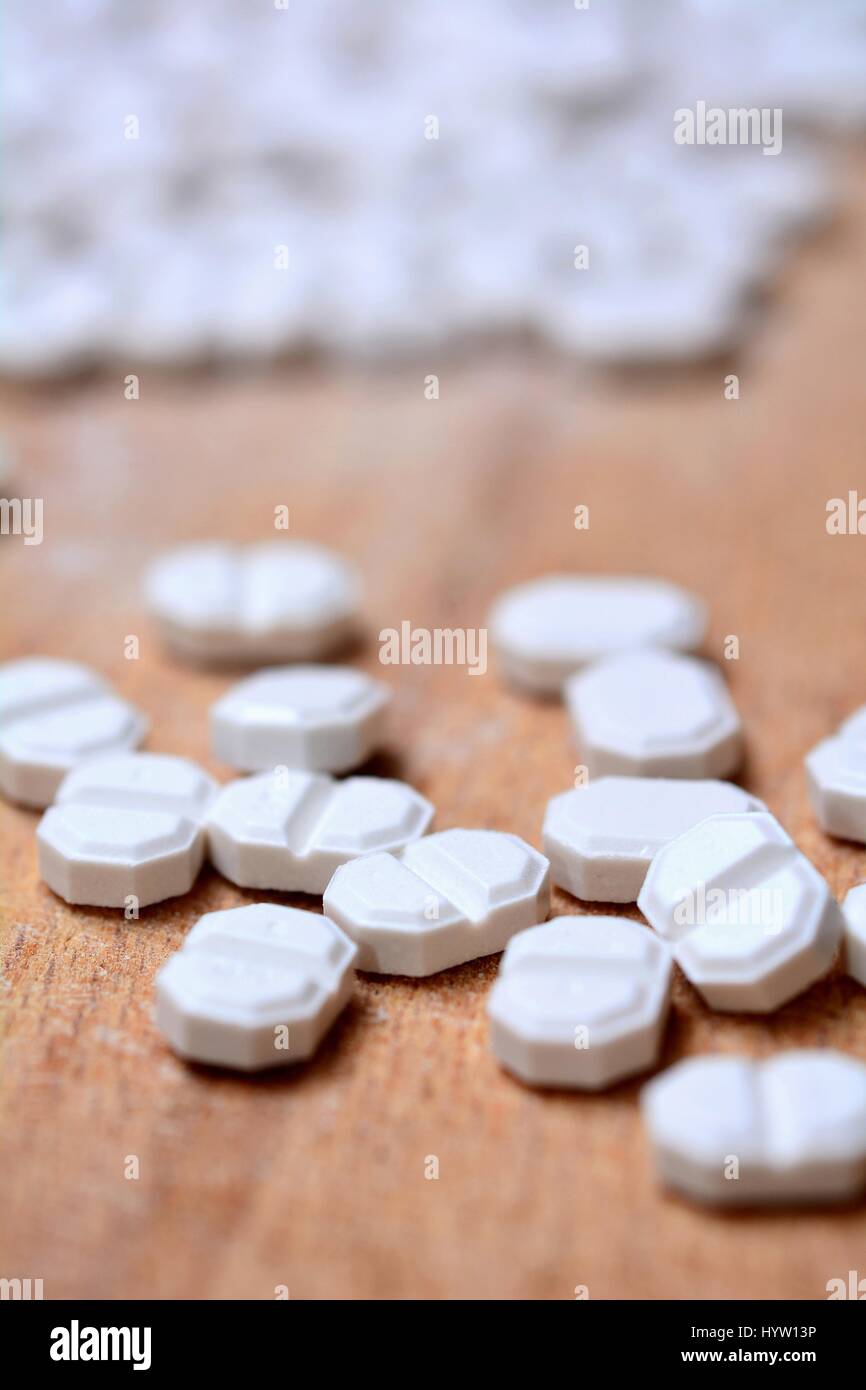 Macro of a White Pills on Wooden Brown Background. Stock Photo