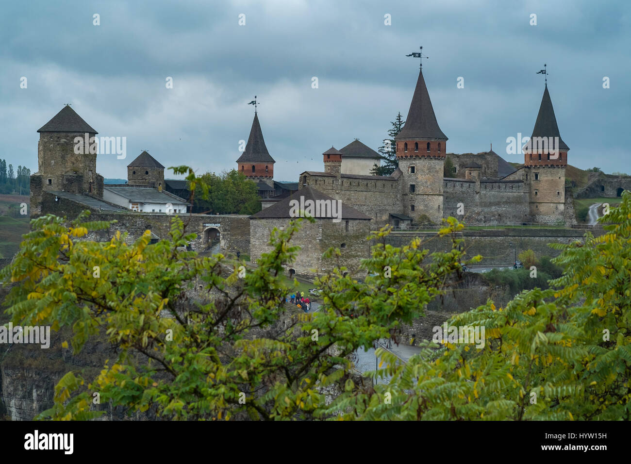 View of the Castle of Kamianets-Podilskyi in Western Ukraine taken on a rainy autumn day. Trees frame the lower part of the image Stock Photo