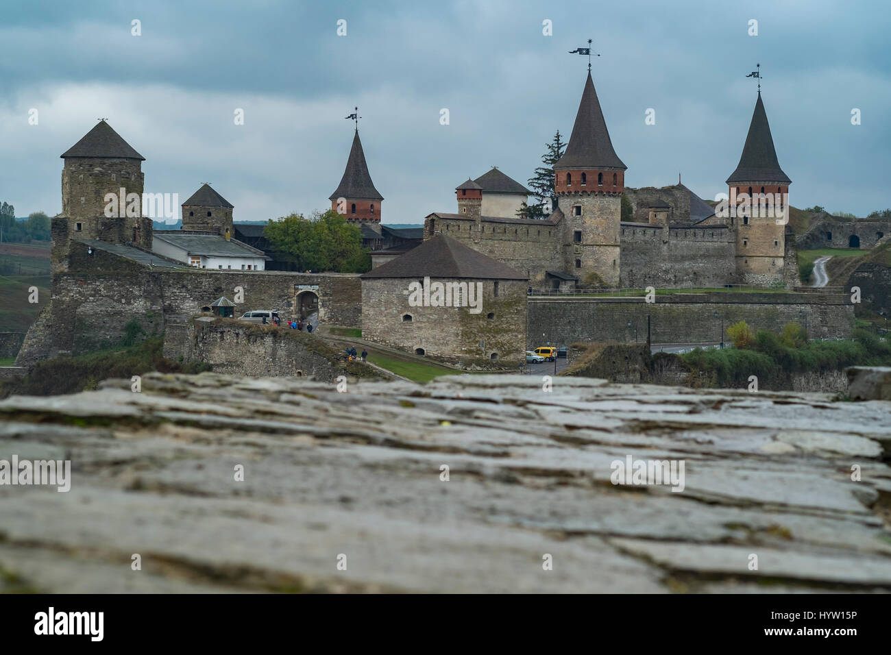 View of the Castle of Kamianets-Podilskyi in Western Ukraine taken on a rainy autumn day. A wall frames the lower part of the image Stock Photo