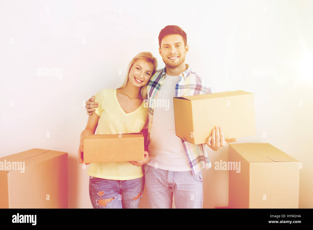 smiling couple with big boxes moving to new home Stock Photo - Alamy