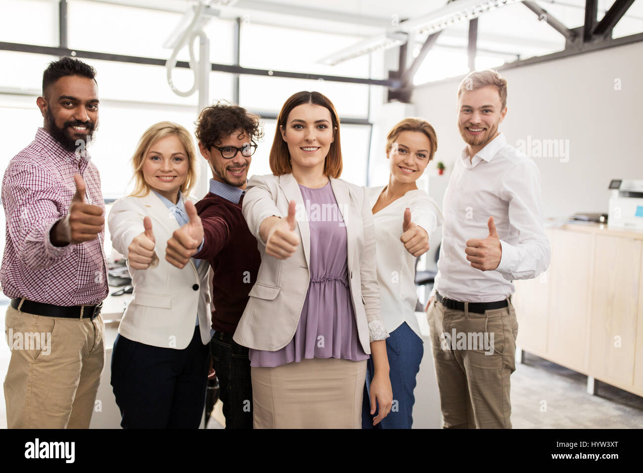 happy business team showing thumbs up at office Stock Photo - Alamy