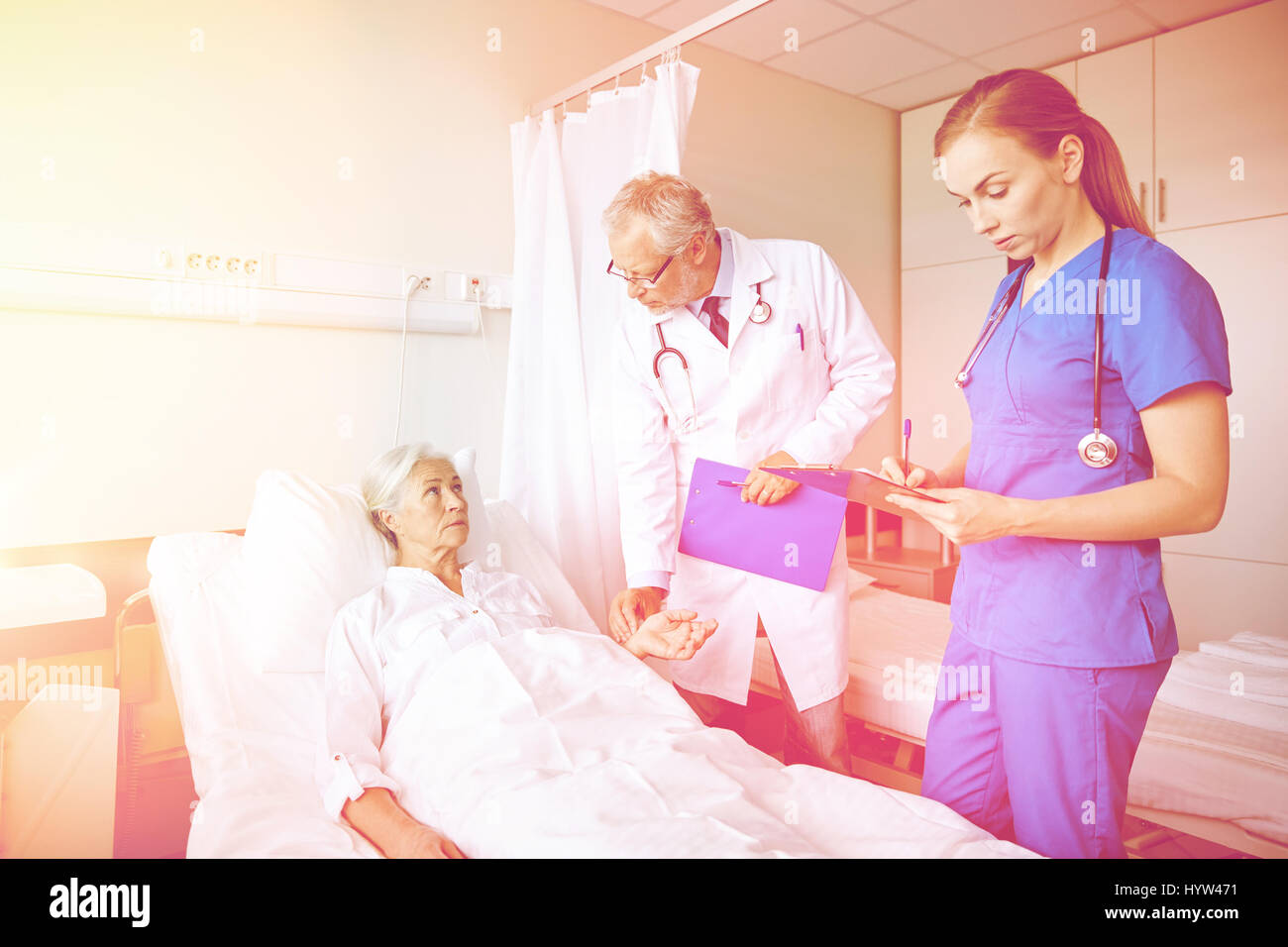 Doctor checking patient hospital ward hi-res stock photography and ...