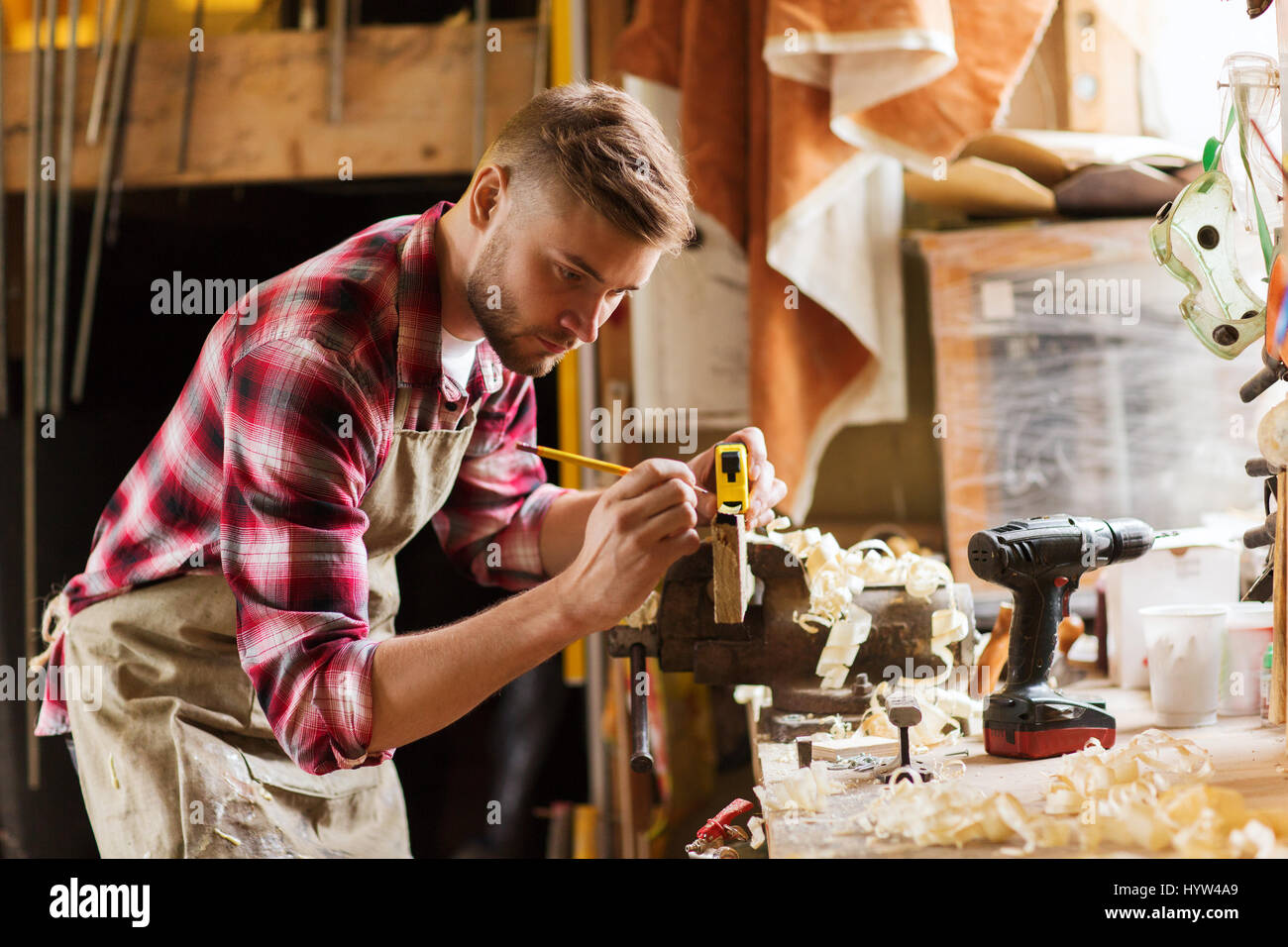 carpenter with ruler measuring plank at workshop Stock Photo - Alamy