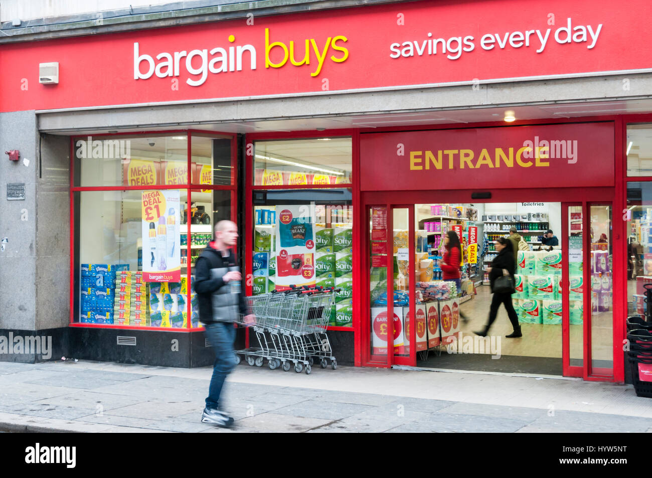 A man (motion blurred) walks past a branch of Bargain Buys in Newcastle Upon Tyne. Stock Photo