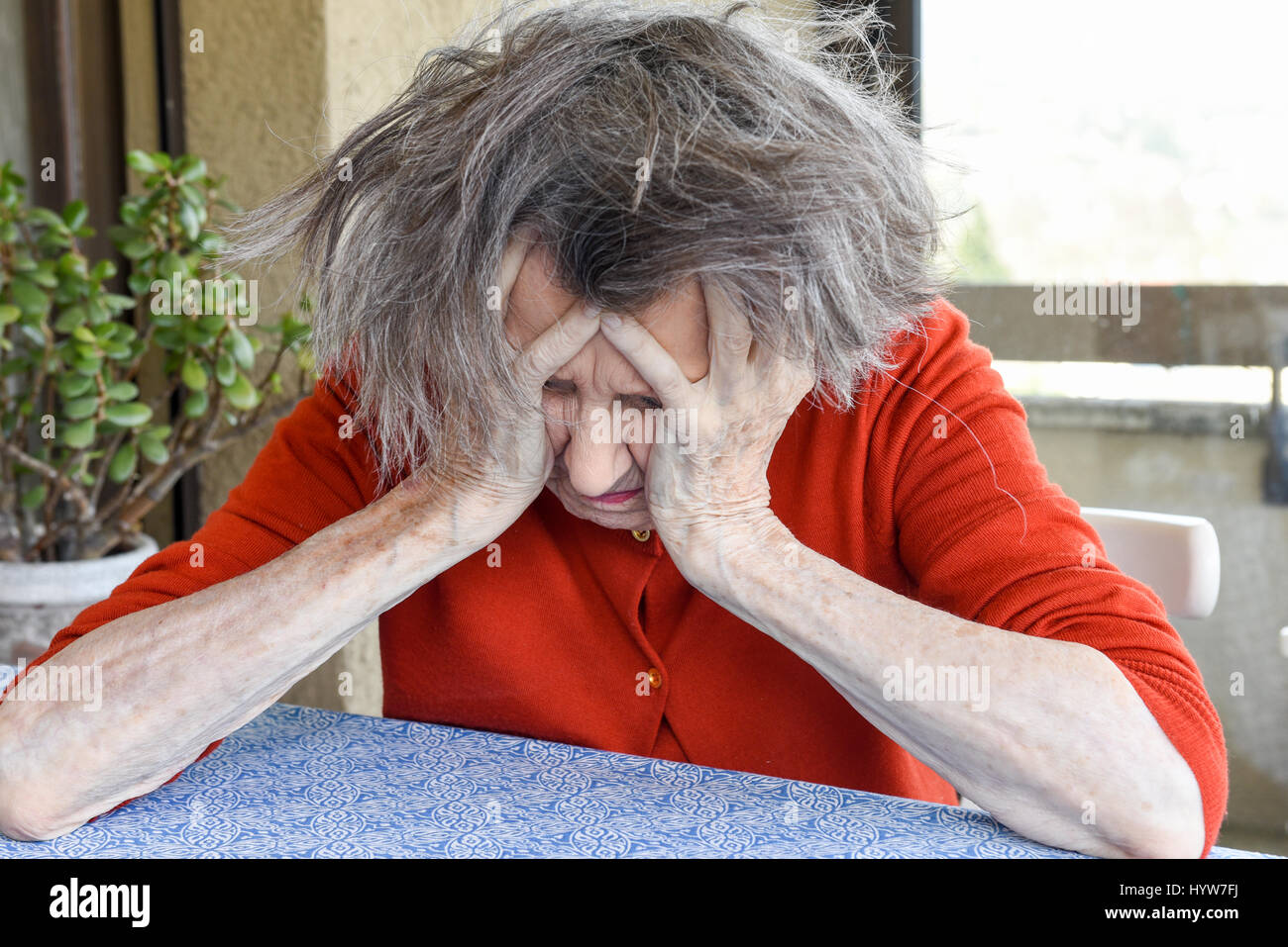 Grunge portrait of an old woman with her hands on her head Stock Photo