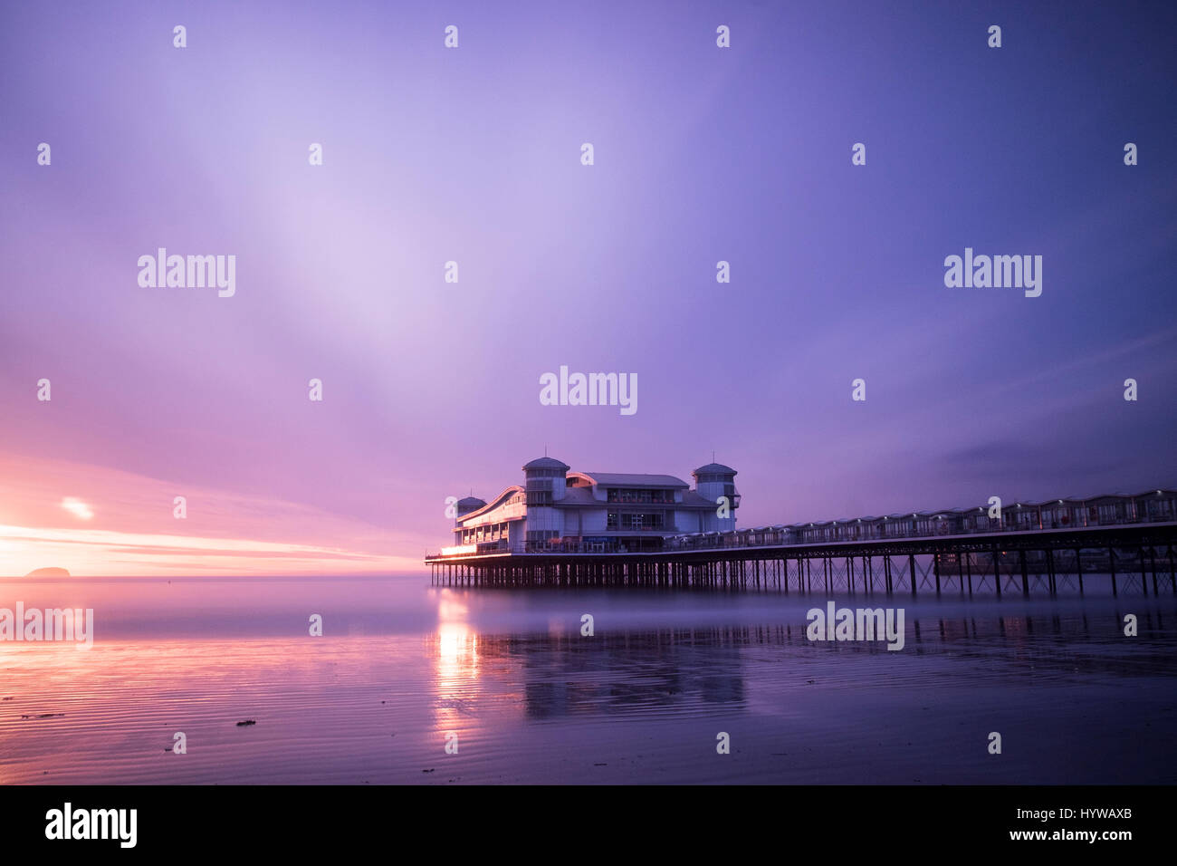 Grand Pier at Weston Super Mare reflected in wet sand and sea at sunset Stock Photo