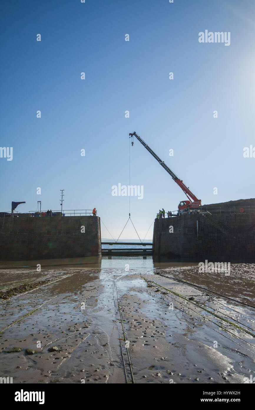 Mousehole, Cornwall, UK. 7th April 2017. The massive timber baulks that protect the harbour at Mousehole during winter, are removed today. Over the weekend the small fishing boats will be put back in the harbour ready for the season ahead. Credit: Simon Maycock/Alamy Live News Stock Photo