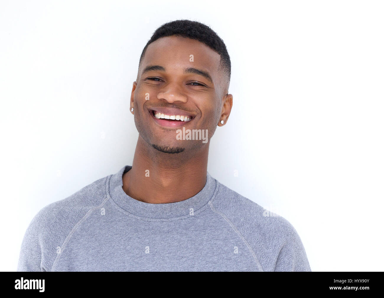 Close up portrait of a handsome young black man laughing on white ...