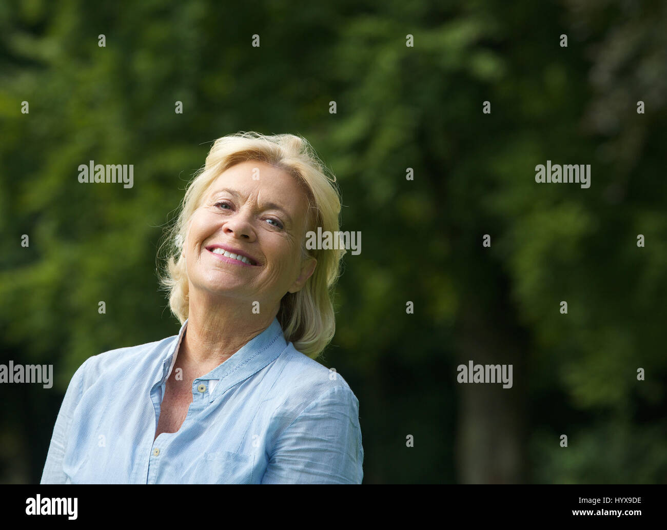 Close up portrait of an elderly woman smiling outdoors Stock Photo