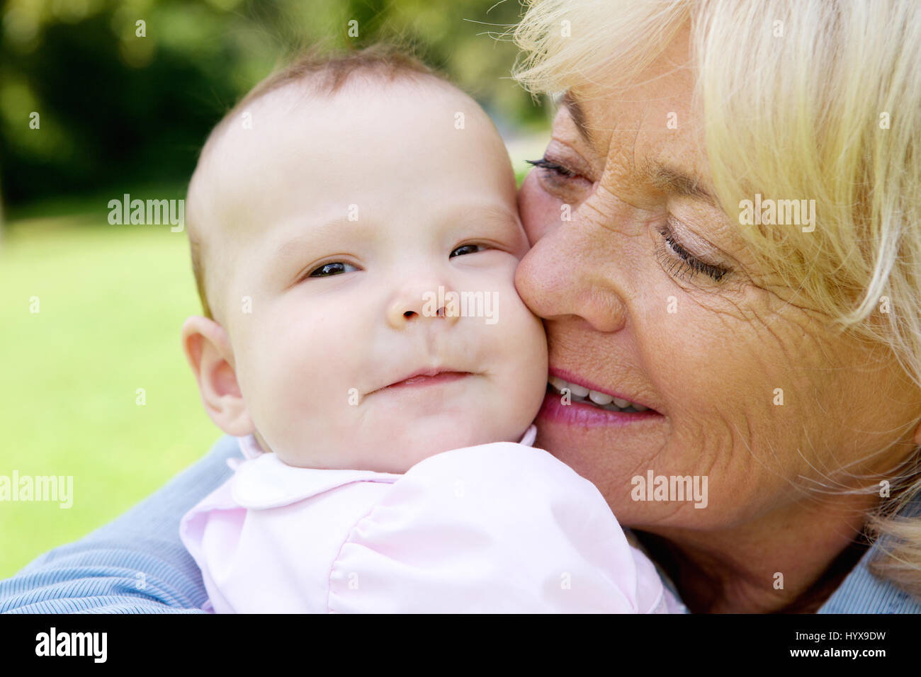 Close up portrait of a senior woman holding cute baby Stock Photo