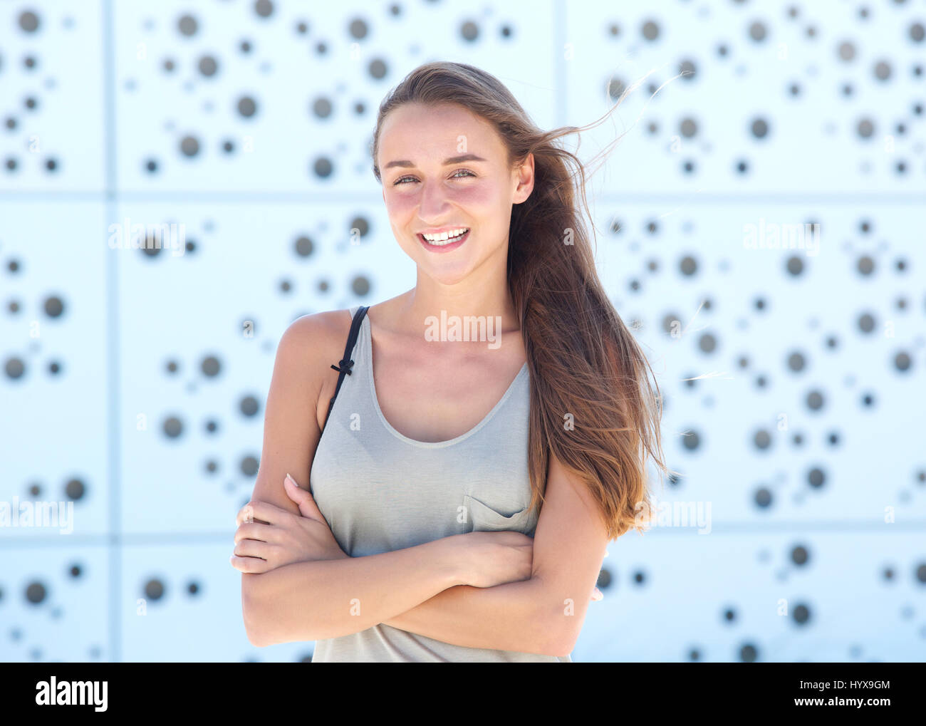 Portrait of a joyful young woman smiling with arms crossed Stock Photo ...