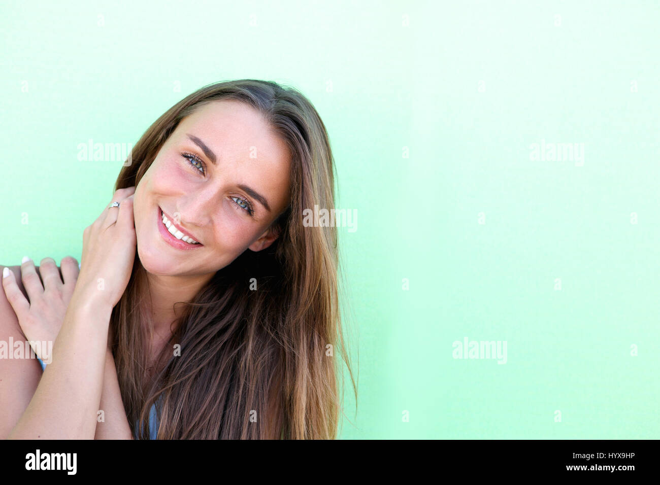 Close up portrait of a cute young woman smiling against white ...