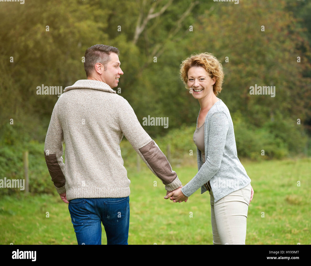Portrait of a happy couple holding hands and walking outdoors Stock Photo