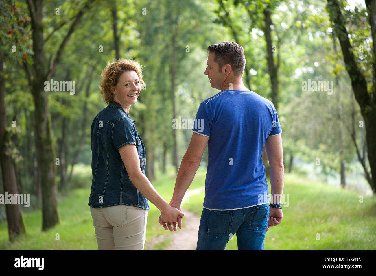Portrait of a couple walking outdoors and holding hands Stock Photo